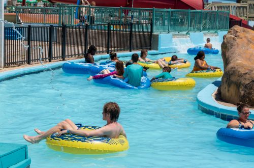 People on blue and yellow rafts floating down lazy river